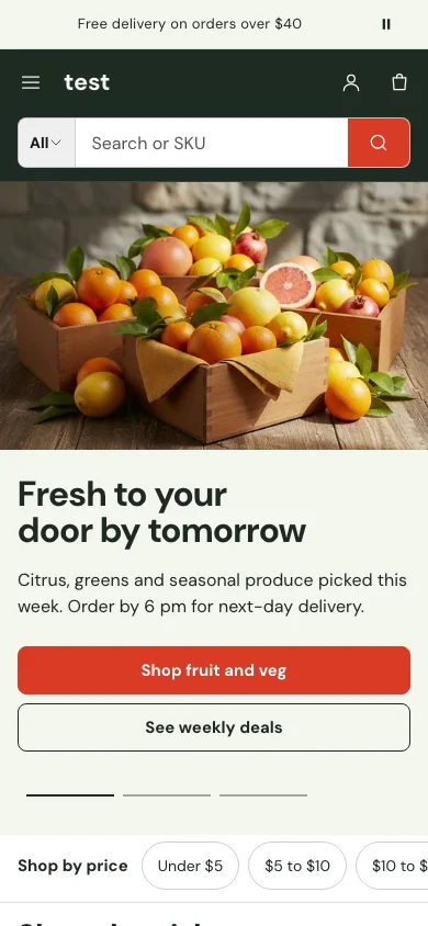 Larder preset of the Manifest theme on a phone: a dark green header with a full-width search field and a red button, above a photo of citrus fruit in wooden crates.